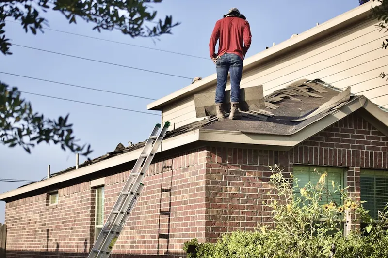 Professional roofer working on a residential roof in Fenwood